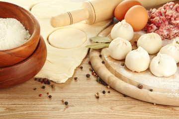 Raw dumplings, ingredients and dough, on wooden table