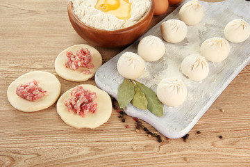 Raw dumplings, ingredients and dough, on wooden table