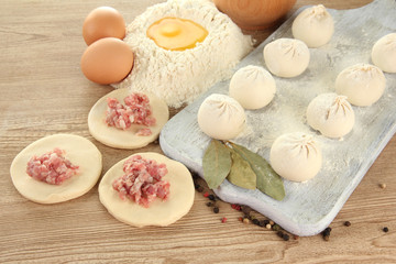 Raw dumplings, ingredients and dough, on wooden table