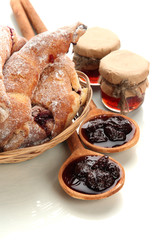 Taste croissants in basket and jam isolated on white.