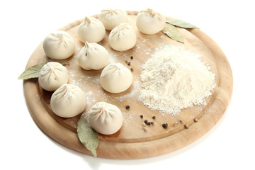 Raw khinkali on wooden desk, isolated on white