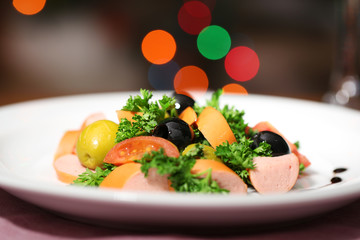 Tasty salad on dark background with bokeh  defocused lights