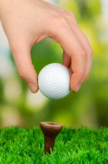 Golf ball in hand on grass outdoor close up