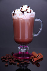 Layered coffee in glass on table on grey background