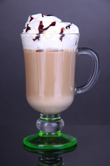 Layered coffee in glass on table on grey background
