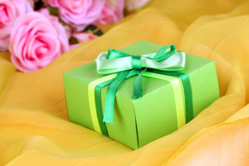 Beautiful gift on flowers background