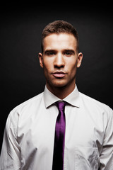 Man with purple tie over dark background