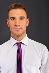 Man with purple tie over dark background