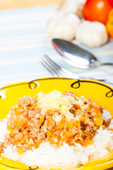 rice topped with ground beef with tomatoes and cheese