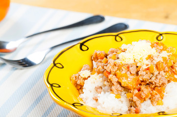 rice topped with ground beef with tomatoes and cheese
