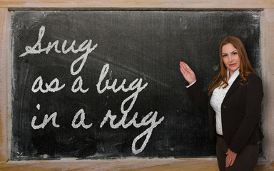 Teacher showing Snug as a bug in a rug on blackboard
