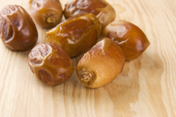 Dried dates on wooden background close up