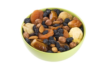 Dried fruits and nuts mixed in green bowl isolated on white
