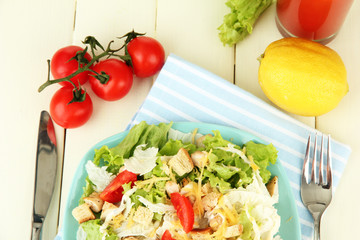 Caesar salad on blue plate, on color wooden background