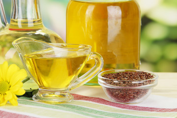 Useful linseed oil on wooden table on natural background
