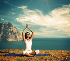 Woman Doing Yoga at the Sea and Mountains - 51771433