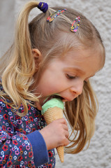 Cute little girl with blond hair and pigtails eating ice cream © Almgren