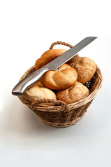 Bread loaves in a wicker basket with knife on top