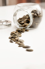 Close up of pumpkin seeds spilling out of glass jar