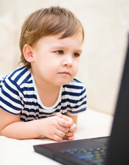 Little boy is playing on laptop