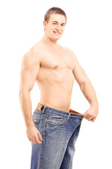 Fototapeta premium Weight loss muscular man in a big pair of jeans