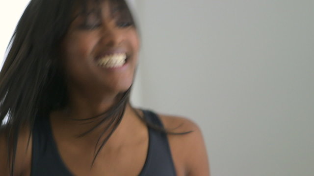 Excited black woman listening to music and dancing