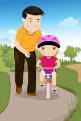 Father teaching his daughter riding a bike