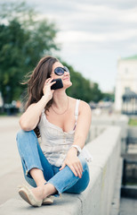 Outdoor portrait of young woman with phone