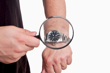 man with magnifier in hand looking at his watch on white backgro