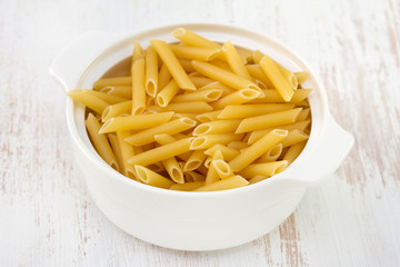 uncooked pasta in white bowl