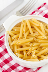 dry penne in white bowl