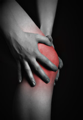pain in the knee. Chiropractor doing massage in sick knee in red