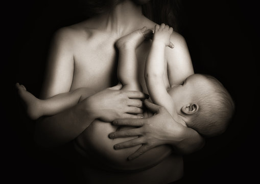 breast feeding. baby in the arms of the mother suckles. monochro
