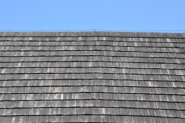 Roof covered with wooden shingles against the sky