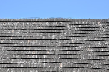 Roof covered with wooden shingles against the sky