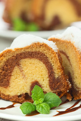 Vanilla and chocolate cake sliced with mint laves  on wooden tab