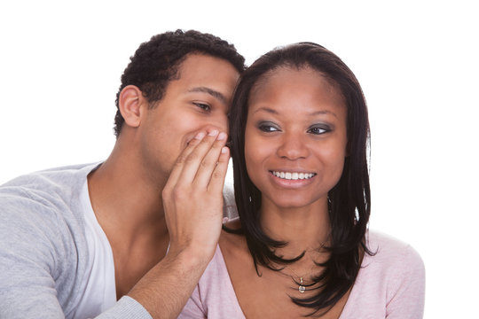 Man Whispering To Girlfriend's Ear