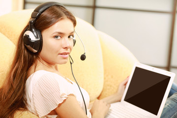 Naklejka premium A woman working on a laptop sitting on a sofa