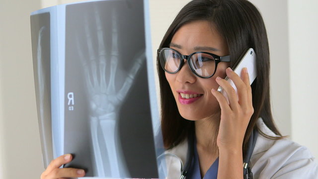 Chinese doctor discussing x-ray with partner on the phone