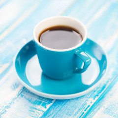 Cup of black coffee on wooden boards, close-up