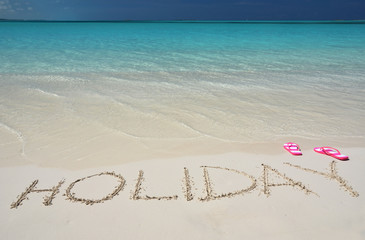 HOLIDAY writing on the sandy beach