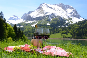 Wine and fruits served at a picnic in Alpine meadow. Switzerland