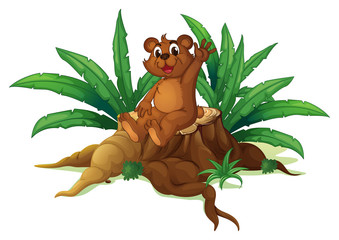 Fototapeta premium A bear waving its hand while sitting above a chopped wood