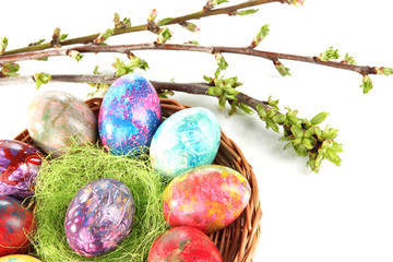 Beautiful Easter eggs in wicker basket isolated on white