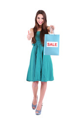 Young beautiful girl in green dress holding bright  shopping