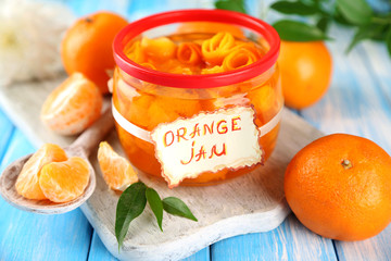 Orange jam with zest and tangerines, on blue wooden table - Powered by Adobe