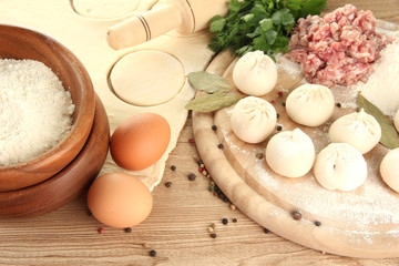 Raw dumplings, ingredients and dough, on wooden table