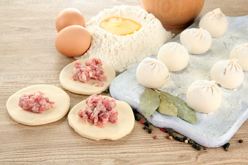 Raw dumplings, ingredients and dough, on wooden table