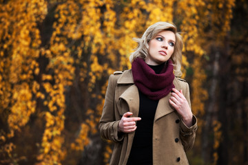 Young blond woman in autumn forest