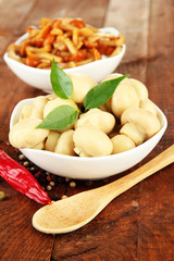 Mushrooms in bowls, on wooden background